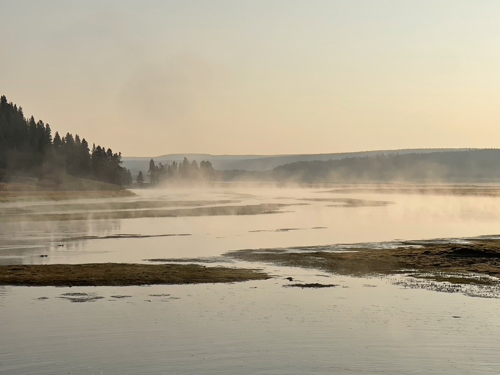 Golden light and mist over quiet water